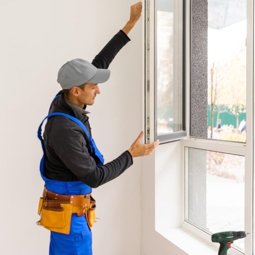 construction-worker-installing-new-windows-house (1) fixing windows